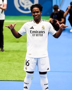 a man standing on top of a soccer field holding his hands out to the side