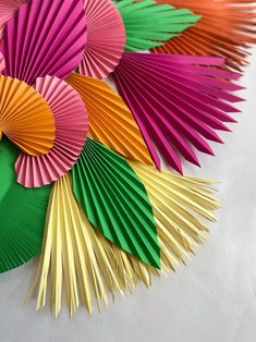 many different colored paper fans on a white surface