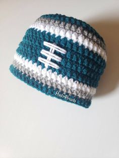 a crocheted hat with the word football written in white and blue on it