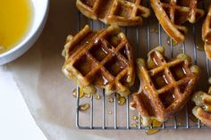 several waffles on a cooling rack with syrup