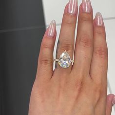 a woman's hand with a ring on it and a diamond in the middle