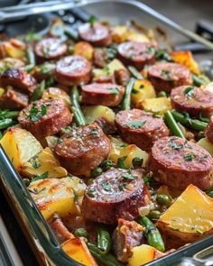 a casserole dish with sausage, potatoes and green beans