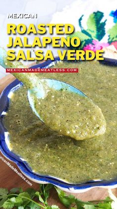 a spoon full of salsa sitting on top of a blue plate with cilantro