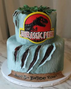 there is a birthday cake made to look like a dinosaur on top of a rock