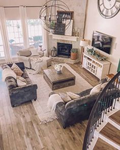 a living room filled with lots of furniture and a clock on the wall above it