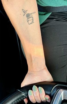 a woman's arm with a small tattoo on it