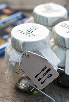 mason jars with spoons and utensils are sitting on a cloth covered table