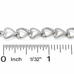 Say "I love you" again and again with a beautiful bracelet lined in sparkling hearts. Sweetly linked together, sterling silver open hearts line this romantic design. The opposite edging of alternating hearts is brightened by shimmering diamonds. Dazzling with 1/4 ct. t.w. of diamonds and polished to a bright shine, this 7.0-inch bracelet is secured with a lobster claw clasp. Elegant Silver Heart-shaped Tennis Bracelet, White Gold Diamond Bracelet With Heart Cut For Anniversary, Silver Heart-shaped Diamond Bracelet For Formal Occasions, Silver Diamond Bracelet For Valentine's Day Wedding, Silver Diamond Bracelet For Wedding On Valentine's Day, Silver Diamond Bracelet For Wedding And Valentine's Day, Heart-shaped Diamond Accent Tennis Bracelet For Anniversary, Silver Diamond Heart Bracelet For Valentine's Day, Sterling Silver Heart-shaped Bracelet In White Gold For Anniversary