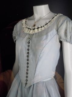 a mannequin wearing a white dress and necklace