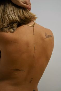 the back of a woman's body with tattoos on her upper and lower back