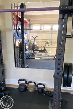 a gym with kettles and barbells in front of a mirror on the wall