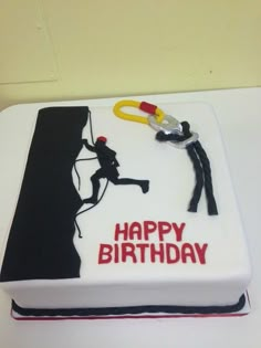 a birthday cake that is decorated with an image of a person on a rock climbing