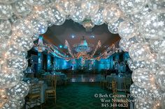 an archway decorated with christmas lights and snow flakes is seen through the center of this photo