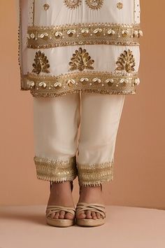 Ivory kurta with sequins, dabka, nakshi and zari hand embroidery. Paired with a matching plain pant with embroidered hemline and an embroidered dupatta. - Aza Fashions Designer Wear Pants With Mirror Work For Eid, Traditional Pants With Mirror Work For Eid, Bollywood Style Festive Bottoms With Mirror Work, Festive Bollywood Bottoms With Mirror Work, Elegant Bottoms With Mirror Work For Festive Occasions, Elegant Festive Bottoms With Mirror Work, Festive Mirror Work Bottoms For Eid, Festive Eid Bottoms With Mirror Work, Elegant White Festive Pants