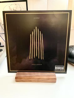 a black and gold framed album sitting on top of a desk