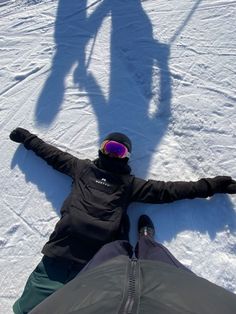 two people laying in the snow with their shadows on them