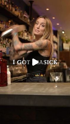 a woman sitting at a bar with her arm in the air