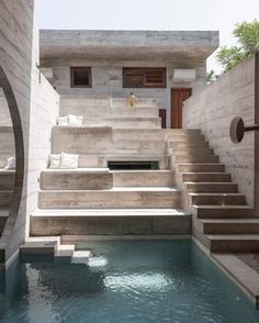 an outdoor swimming pool with steps leading up to the house's upper deck area