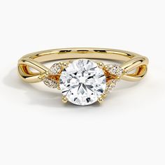 a yellow gold engagement ring with a round cut diamond in the center and side stones on each band