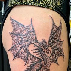 a woman's thigh with a dragon tattoo on it