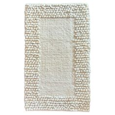 a white rug with a square design on the top and bottom part of it, in front of a white background