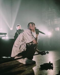 a man sitting on top of a stage holding a microphone