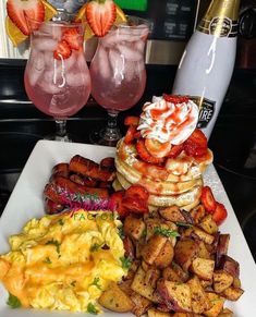 a white plate topped with waffles, eggs and fruit