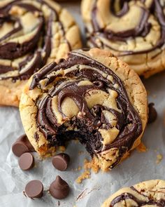 chocolate swirled cookies on top of parchment paper with one bite taken out and the other half eaten