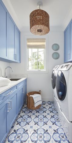 a washer and dryer in a blue and white bathroom with tile flooring