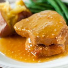 a white plate topped with meat covered in gravy