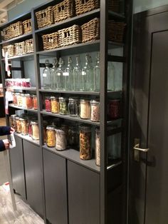 the shelves are filled with jars and baskets