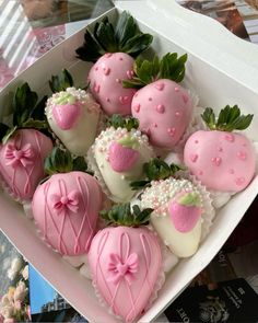 a white box filled with pink and white chocolate covered strawberries