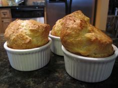 three small white dishes filled with food on top of a counter