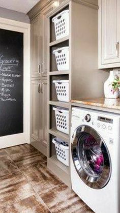 a washer and dryer in a room with a chalkboard on the wall