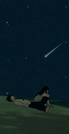 a person laying on the ground in front of a sky full of stars and a shooting star