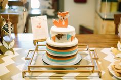 there is a cake on the table with other items in front of it and an animal figurine sitting on top