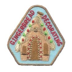 an embroidered patch with the words gingerbread cottage on it and a christmas tree in front