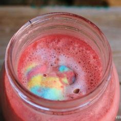 a jar filled with liquid sitting on top of a wooden table