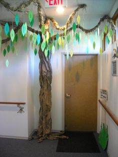 an office decorated for christmas with paper leaves hanging from the ceiling