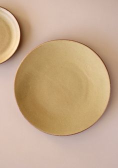 two yellow plates sitting next to each other on a table