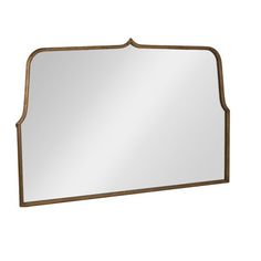 a mirror that is sitting on top of a white wall with a gold trim around the edge