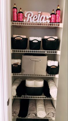 an organized closet with shelves and baskets filled with towels, blankets, and other items