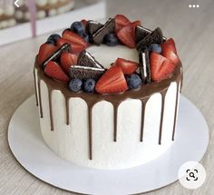 a white cake with chocolate and strawberries on top