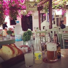 a table topped with lots of food next to bottles of water and glasses filled with liquid