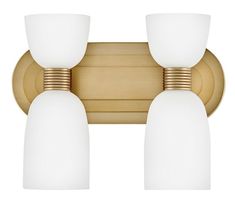 two light bathroom fixture with brass finish and white glass shades on the top, against a white background