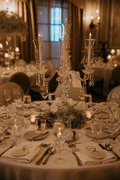 the table is set with silverware and candles for an elegant wedding reception or special event