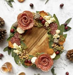 a wreath made out of meats, cheese and leaves on top of a table