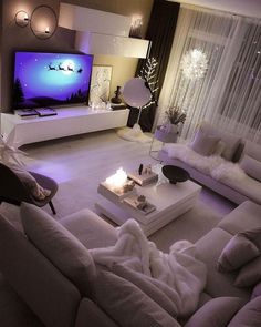 a living room filled with furniture and a flat screen tv sitting on top of a wall