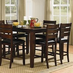 a dining room table with chairs and plates on it