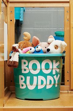 stuffed animals are sitting in a book buddy bin